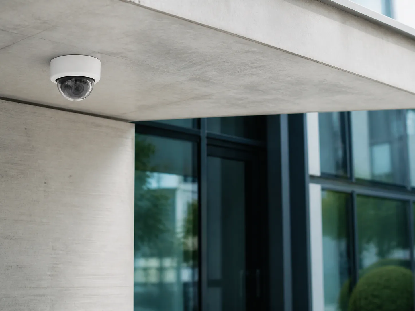 Domecamera onder de luifel van een hedendaags gebouw